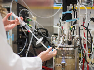 In‑line process sampling using a syringe filter connected to a bioreactor vessel in a laboratory environment.