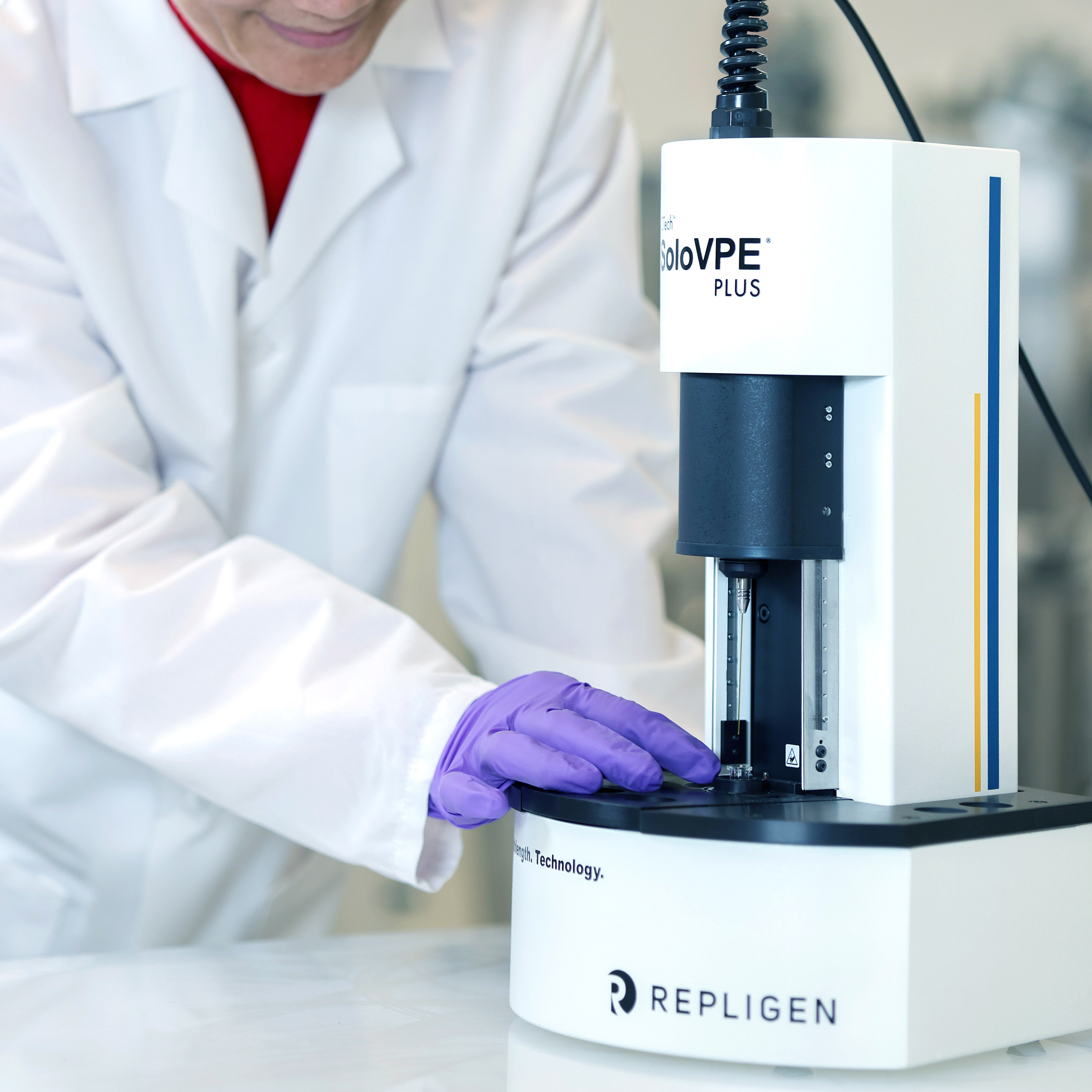An image of a Quality Control (QC) or Quality Assurance (QA) member using the PATsmart SoloVPE PLUS at-line UV-Vis spectrophotometer system, a downstream bioprocessing device that typically is used in drug development and production and measures concentration in quality, manufacturing, and process development labs.